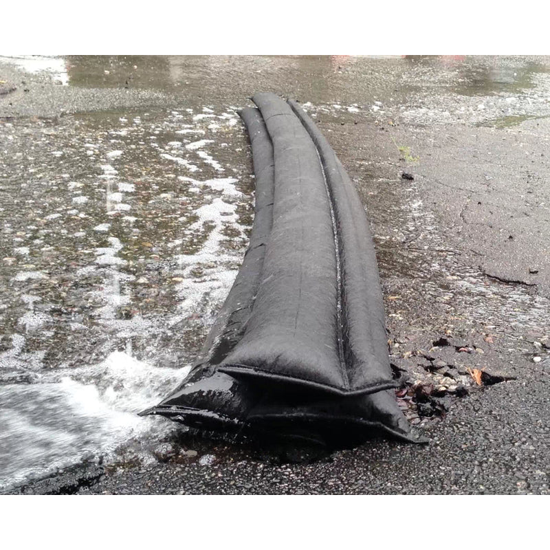 ick Dam 6" x 17 ft. Flood Barrier QD617 blocking water from a driveway